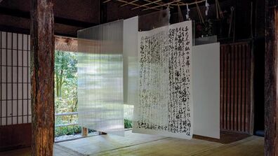 Pieces of paper hang from a rack in a traditional Japanese interior