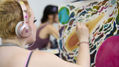 Student painting a colorful canvas.