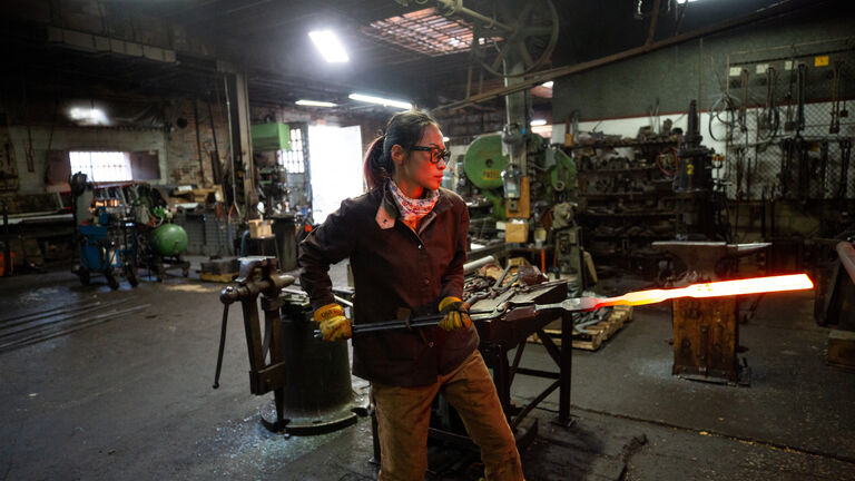 A person in a metal works studio. 