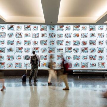 Xray images of people's carry on bags lining a wall at the San Diego International Airport. 