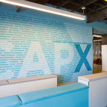 The CAPX offices, showing a large wall made up of text detailing different careers in art and design.