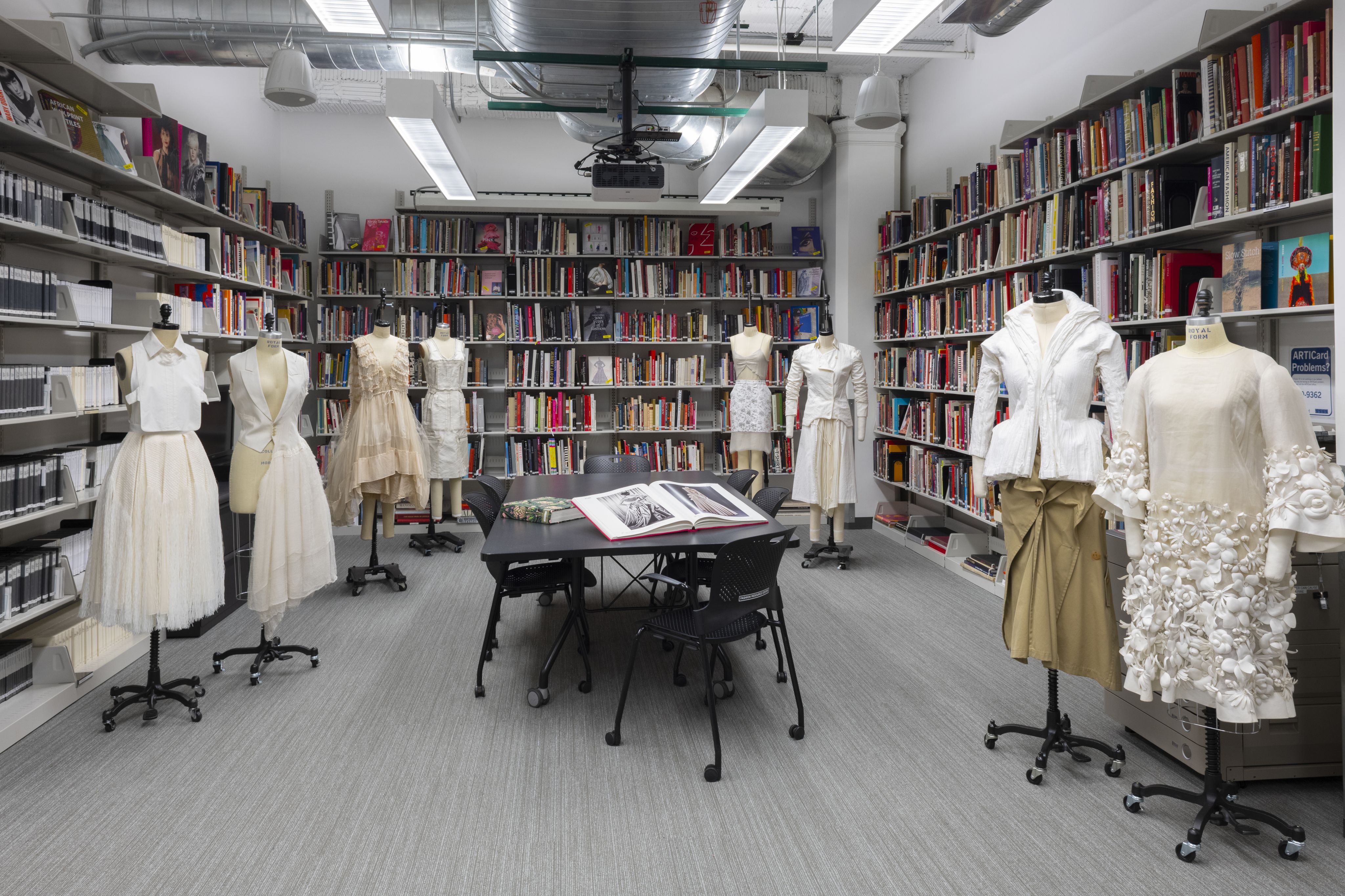 Dress forms in front of bookshelves in the Fashion Resource Center