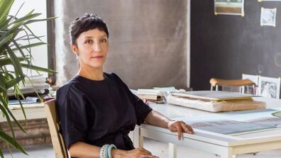 Artist and professor Maria Gaspar seated at table 