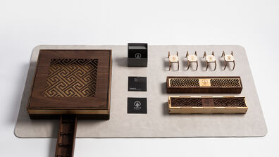 A designer utensil box that includes a set of cutlery, a custom leather mat, napkins, and bespoke packaging.