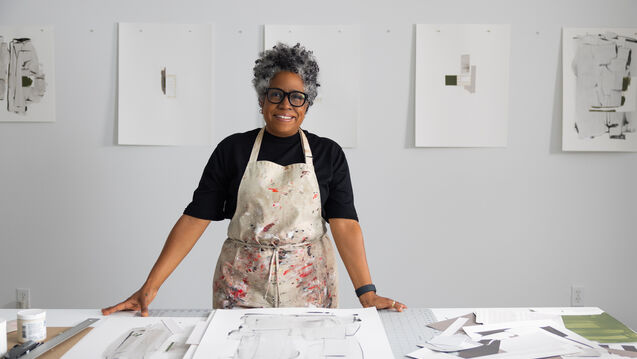 Jennie C. Jones standing in front of her acoustic panel artworks at a studio.