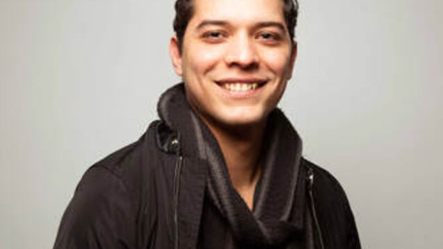 A portrait of an arts administrator in front of a white background