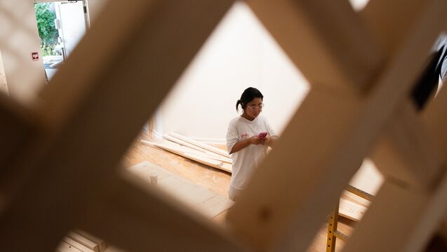 Soo Kim stands behind the pavillion during installation