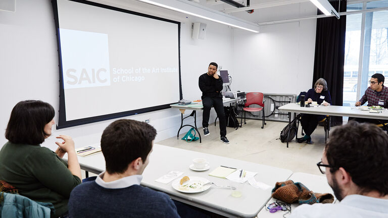 A teacher lecturing in front of a classroom. 