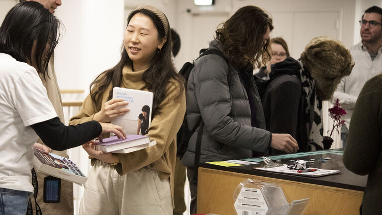 Several students looking at books and other items in library