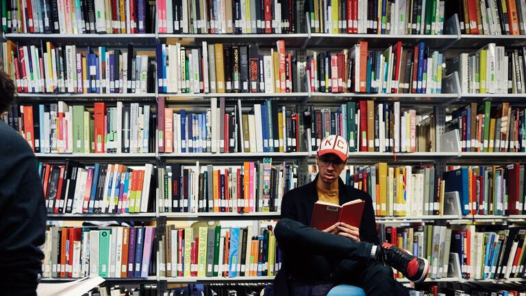 A person sitting and reading inside a library