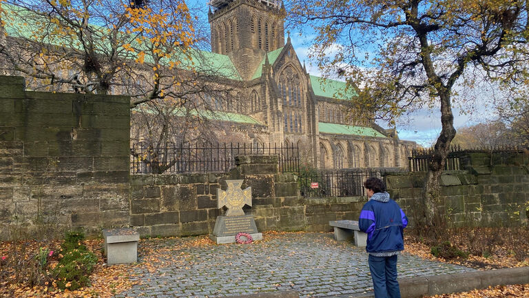 A person standing in front of a majestic cathedral, admiring its grandeur and architectural beauty.