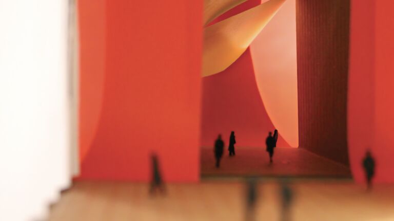 A photo of a room with red walls and the shadows of people walking around