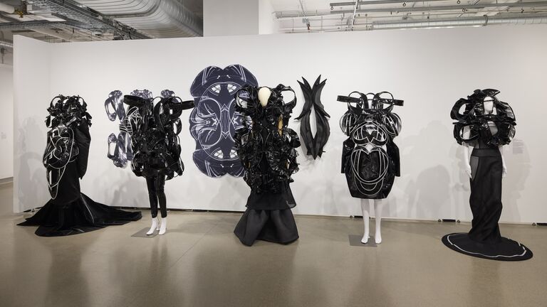 Five black garments on display in front of a white background