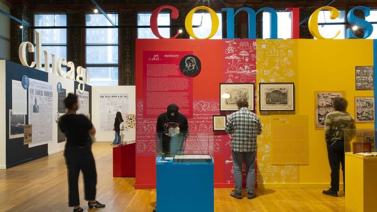 Several guests looking at the colorful walls of Ware's exhibition