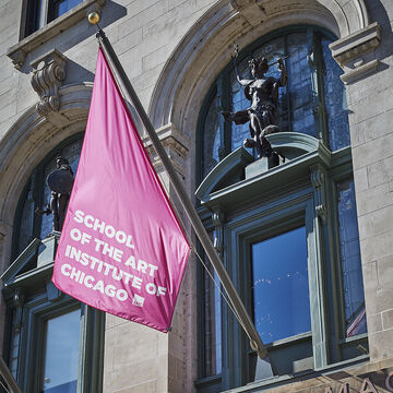 Exterior shot of a pink SAIC flag at the MacLean Center entrance.