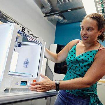 A person demonstrating how to use a 3D printer.