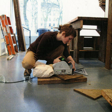 Sara working with a sander in a studio