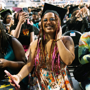 A photo of three students at SAIC's Commencement ceremony.