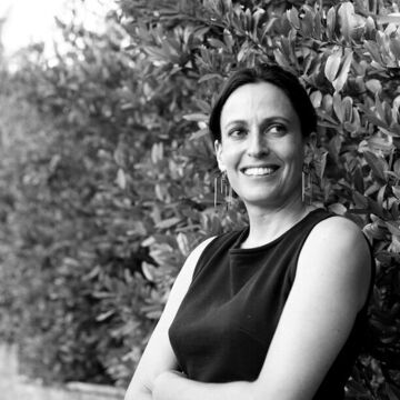 Black and white portrait of a white person outdoors and smiling 