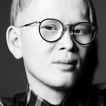 Black and white headshot of a person wearing glasses 