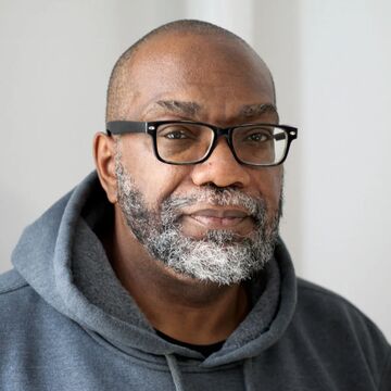 Headshot of a Black man with glasses. 