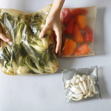 Hands hold plastic alternative containers of veggies