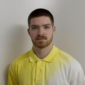 An artist in a yellow and white polo