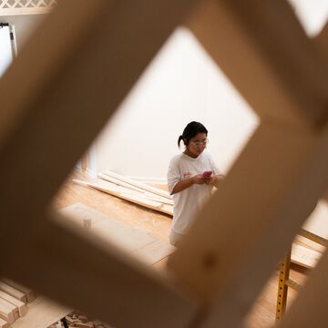 Soo Kim stands behind the pavillion during installation