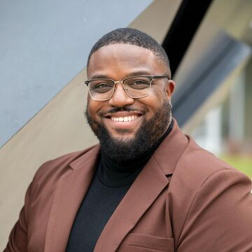 Headshot of an adult Black man smiling