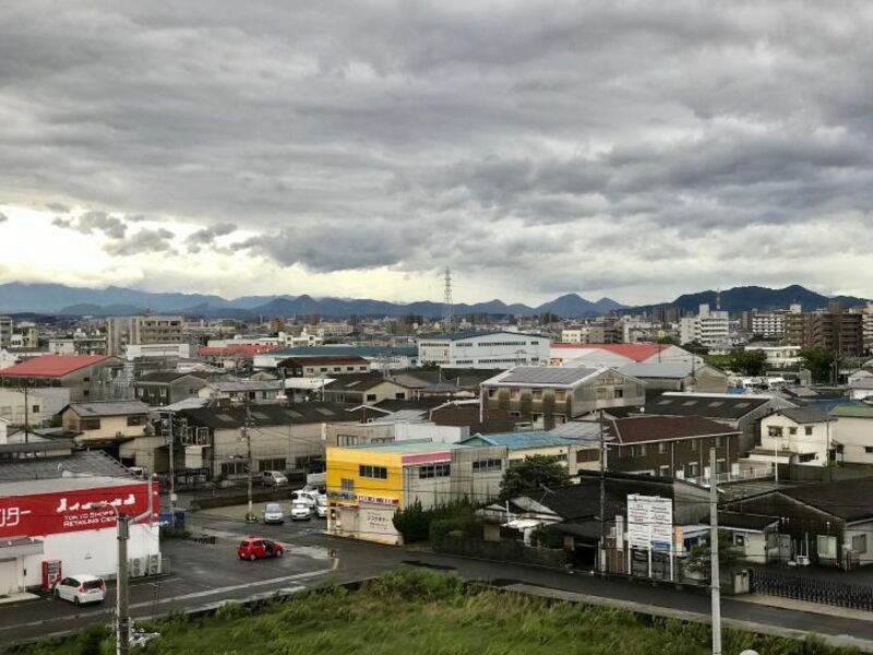 A photo of a Japanese town with mountains in the distance