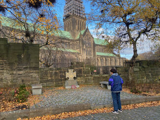 Man in a blue jacket standing in front of Glasgow Central Cathedral in the autumn