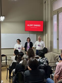 Three adults giving a presentation in a classroom