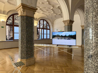 A TV screen in a large room with arches