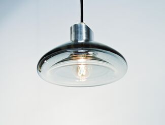 A glass pendant lamp that's turned on.