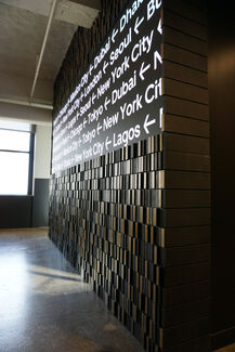 A black wall with the names of cities written on it in white