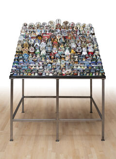 Many rows of snowglobes on a steel table