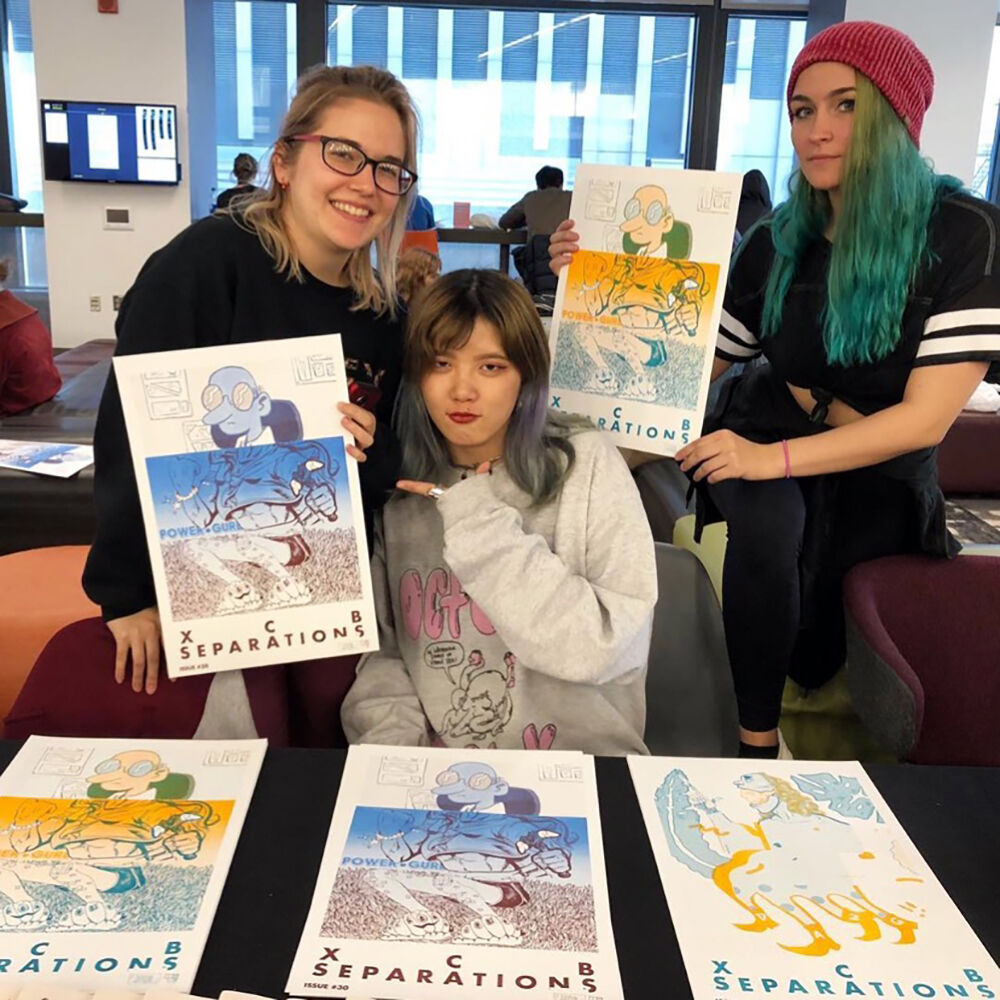 Image of three students holding art.