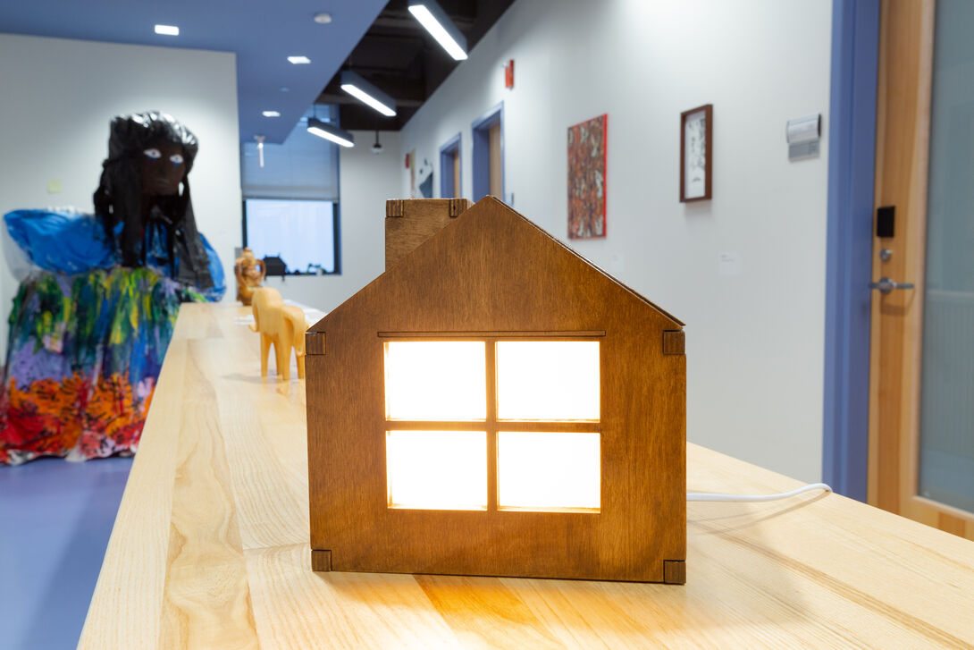 a sculpture of a house glowing with light