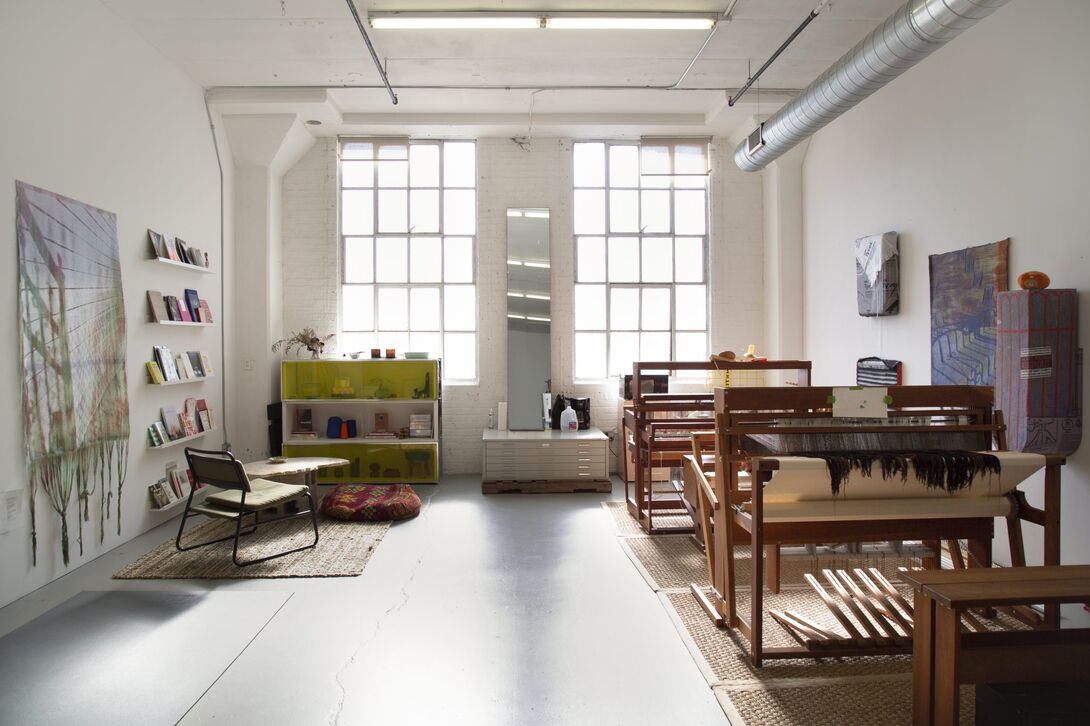 A well lit weaving studio with tall ceilings and high windows