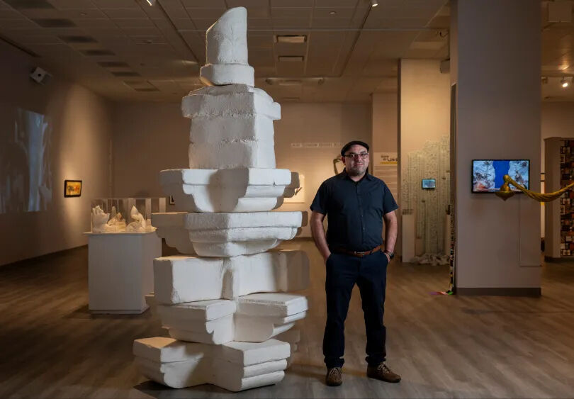 Shaurya Kumar poses next to his sculpture “What is Seen and Unseen: Mapping South Asian American Art in Chicago” on display at the South Asia Institute in Chicago, Oct. 24, 2024. 