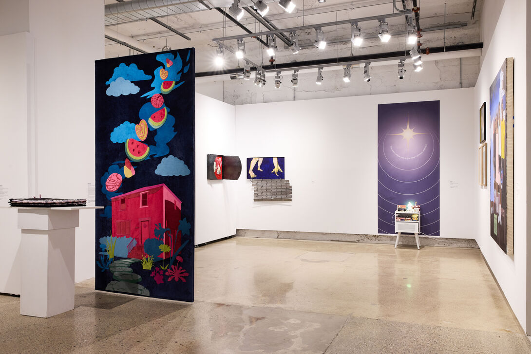 An artwork in the foreground depicting a red house and watermelons, and an artwork in the background depicting a star.