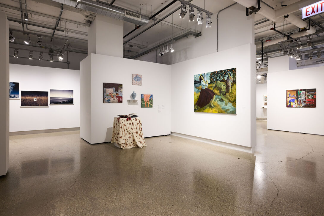 A painting of a woman by a river on one gallery wall, two smaller paintings on the opposite wall.
