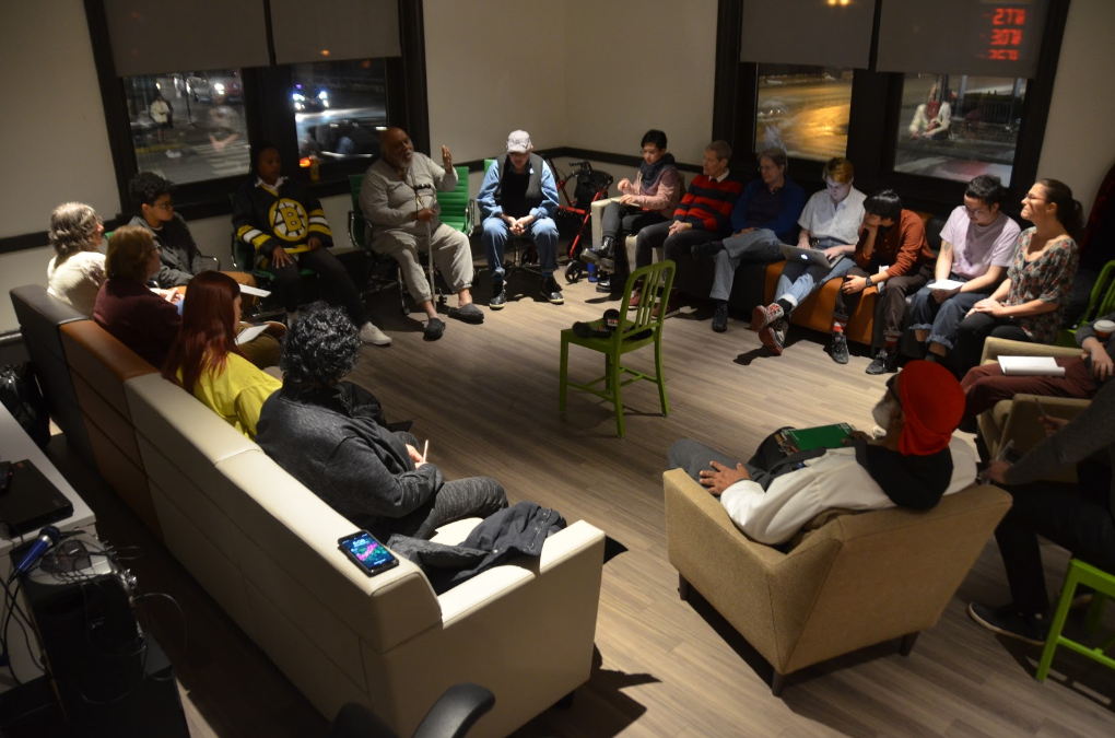 A group of students, faculty, and guests sit in a circle having a dialogue at the Center on Halsted